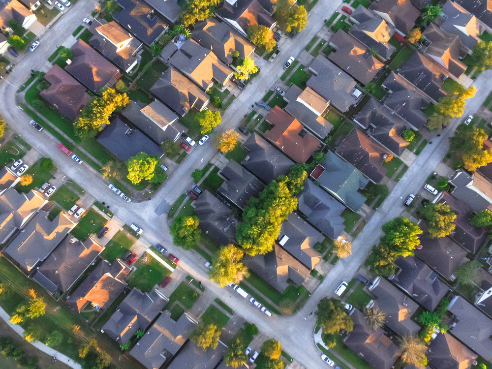 Vista aérea de bairro residencial com imóveis valorizados e ruas organizadas.